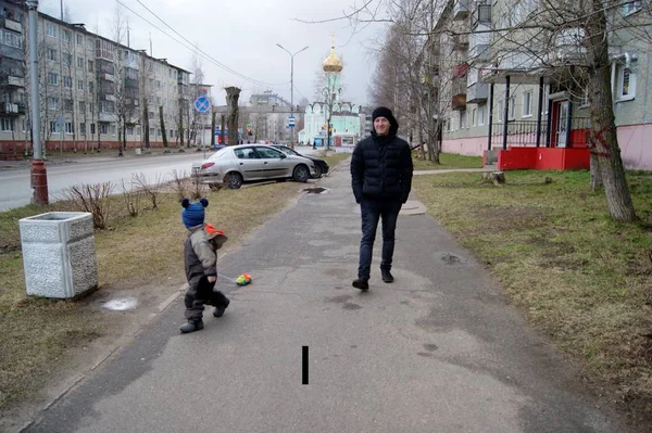 Jaro v provinčním městě, otec chodí s dítětem, které válčí psací stroj na strunu — Stock fotografie