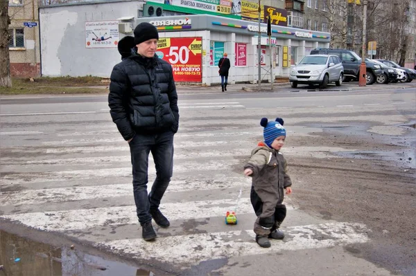 Jaro v provinčním městě, otec chodí s dítětem, které válčí psací stroj na strunu — Stock fotografie