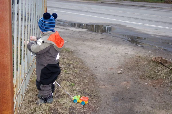 Lente in een provinciale stad, de baby loopt en rolt een typemachine op een String — Stockfoto