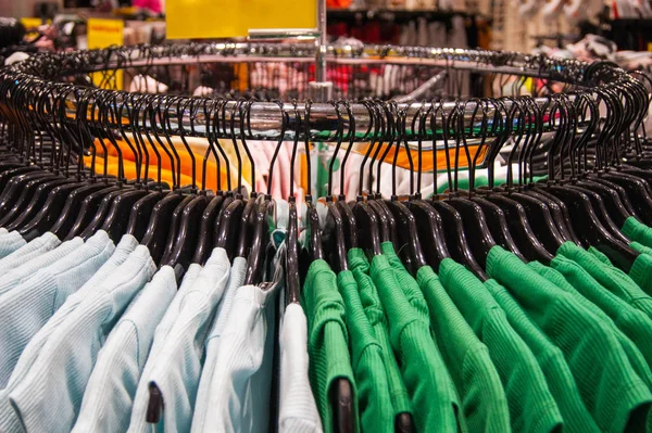 Giyim mağazası. Parlak şeyler siyah omuzlarda düzgünce asılı.