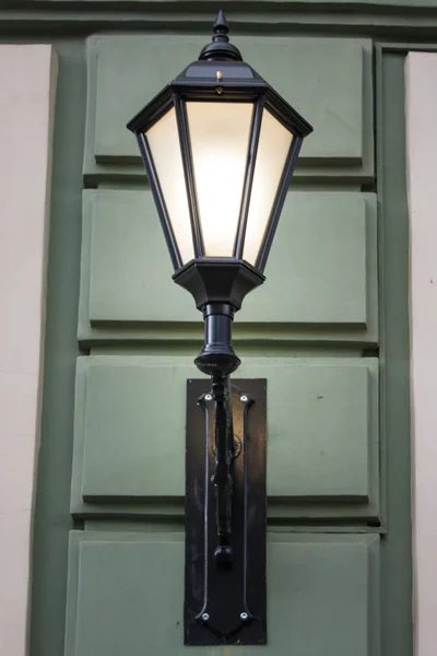 Foto di uno street design. Una lampada elettrica vintage su uno degli edifici assomiglia a una vecchia lampada con una lampada all'interno — Foto Stock