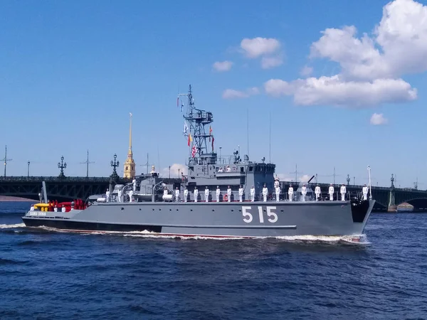 Парад військово-морських технологій. Сірий Військовий корабель з моряками в офіційній білій формі на борту на тлі мосту — стокове фото