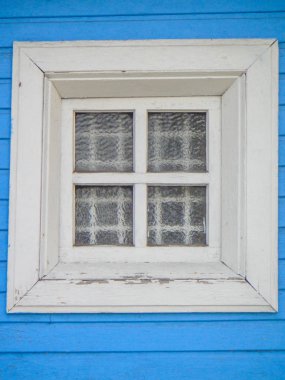Mavi boyalı ahşap duvar arka plan karşı bir kafes ve bir guipure perde ile beyaz ahşap pencere - fotoğraf.