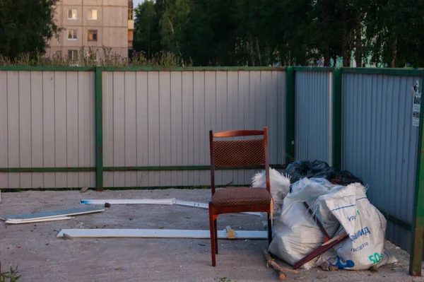 Birkaç çok katlı binaların bahçesinde çöp toplamak için bir yer. Editoryal fotoğraf. Birisi sandalyeyi attı.