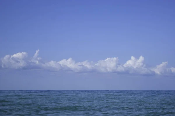 Fehér felhők felett kék nyugodt tenger — Stock Fotó