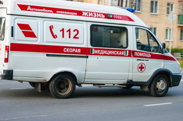 Bir ambulans arabası şehirde dolaşıyor. Bir arabada yazıyor - Rusça'ya çeviri - hayat kurtaran bir araba, ambulans