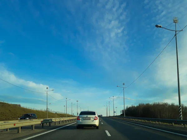 Ufka giden bir yol ya da otoyol. Arabanın penceresinden bak. Kuzey loş yaz, beyaz bulutlu mavi gökyüzü. Yolculuk, eve dönüş yolu..