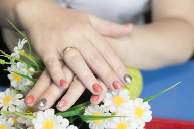 Manikür zarif kadınların ellerini süslüyor.