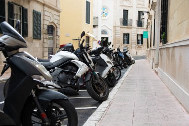 Akdeniz'in dar caddesinde yolda park halindeki motosikletler.