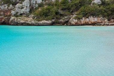 Arka planda kayalar ile güzel turkuaz deniz.