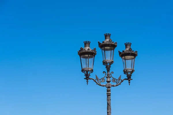 Triple street lamp with bright blue sky and space for copy — Stock Photo, Image