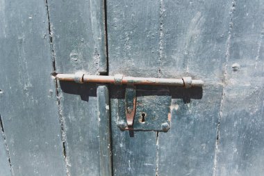 Eski paslı sürgü ya da yıpranmış yeşil bir kapının sürgüsü.