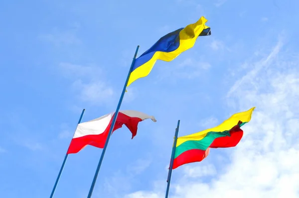 Flags of Lithuania, Ukraine and Poland against the sky