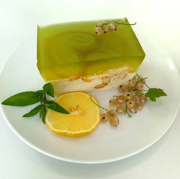 Cheesecake dessert with lemon and kiwi jelly decorated with white currants and mint