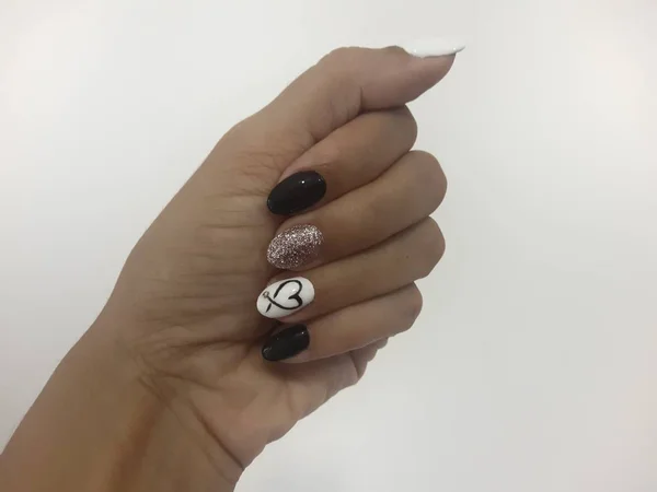 Manicure in black and white color with a heart on a nameless in a romantic style. Hand nails