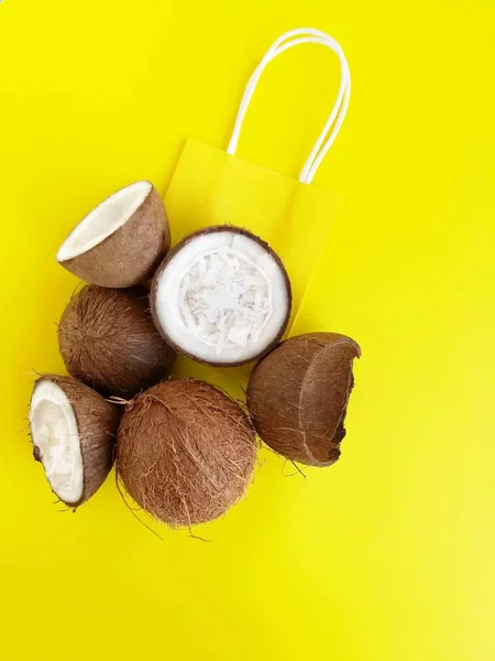 Sac à provisions noix de coco et papier sur fond jaune vif . — Photo