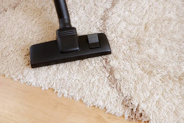 Modern dammsugare på en beige matta trä parkett. Begreppet hushållning, hushållsarbete, dammsuga mattan. Kopiera utrymme för text, uppifrån. — Stockfoto