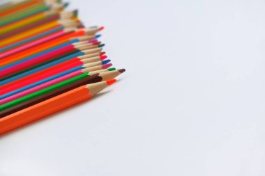 Okulda çizmeyi öğrenmek için beyaz arka planda çeşitli renkli kalemler çapraz olarak sırayla ortaya konmuştur. Seçici odaklama ile, metin için spase kopyalayın.
