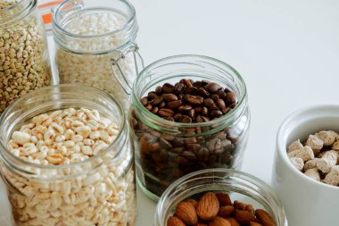 Çeşitli tahıllar, kahve, fındık, cam kavanozlarda kepek. Sıfır atık konsepti, ücretsiz plastik.