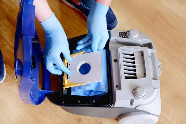 Close-up of a man's hand installing a clean empty dust bag in a  vacuum cleaner. — Stock Photo, Image