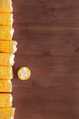Ahşap bir arka plan üzerinde taze mısır koçanları Düz yatıyordu kompozisyon. Üst görünüm, metin için kopya alanı