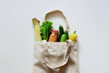 Çeşitli taze sebze ve meyve, ekmek, tahıllar bir eko yeniden kullanılabilir çanta. Sıfır atık kavramı. Sağlıklı yiyecekler. Üst görünüm, metin için alan.