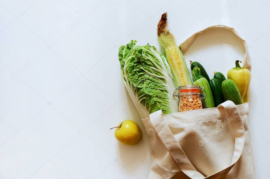 Various fresh vegetables and fruits, bread, cereals in an eco reusable bag. Zero waste concept. Healthy food. Top view, space for text.