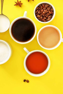 Kahve çeşitli fincan düz yatıyordu kompozisyon, şeker ile çay, krem ve parlak sarı arka plan üzerinde yıldız anason. Kahve molası. Üstte görüntü.