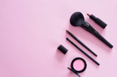 Dekoratif kozmetik, farklı makyaj fırçaları, allık, pembe bir arka plan üzerinde ruj Düz yatıyordu kompozisyon. Üst te. Minimalist yaşam tarzı.