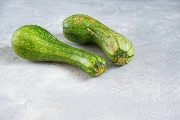 Två Bortskämda Zucchini Grå Bakgrund Fula Matkoncept Ekologiska Grönsaker Närbild — Stockfoto