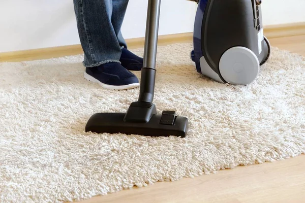 家の中で掃除機でカーペットのクリーニング 片足を閉めろ宿題のコンセプト テキストのコピースペース — ストック写真
