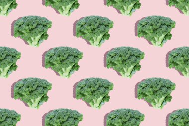 Pembe arka planda kusursuz, düzenli, yaratıcı brokoli dilimleri. Üst görünüm. Fotoğraf kolajı, sert ışık, gölge, pop sanat tasarımı. Yemek blogu, sebze geçmişi. Kumaş üzerine baskı, ambalaj kağıdı.