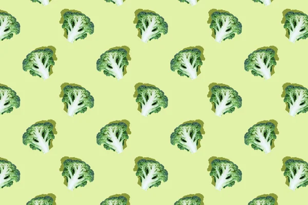 明るい緑の背景にブロッコリースライス シームレスな規則的なパターン トップビュー 写真のコラージュ ハードライト ポップアートデザイン フードブログ 野菜の背景 布に印刷 包装紙 — ストック写真