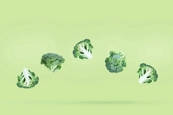 Pět Brokolic Volně Vznáší Zeleném Pozadí Mírným Stínem Tvůrčí Koncept — Stock fotografie