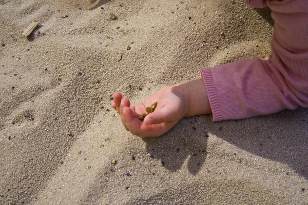 Dětská ruka v písku při hraní. — Stock fotografie