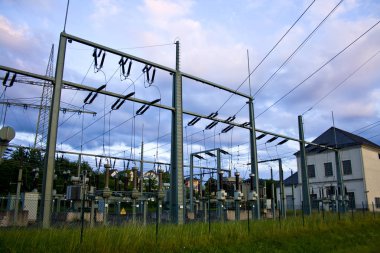 Yüksek voltajlı elektrik hatları. Elektrik dağıtım istasyonu. Yüksek voltajlı elektrik iletim kulesi. Güç hatları ve trafoları olan dağıtım elektrik santrali.