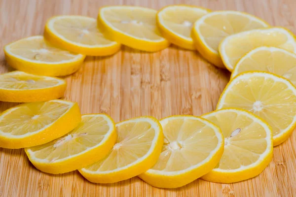 Fresh yellow Lemon slices on the old wooden table.