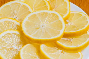 Eski ahşap masada taze sarı Limon dilimleri. 