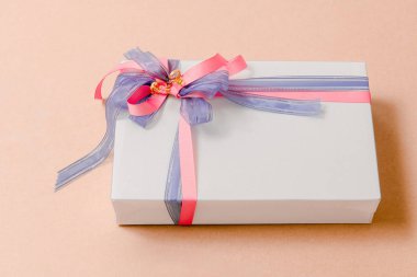 Lüks kutu pembe arka plan üzerinde mavi ve pembe kurdeleler ile bağlı