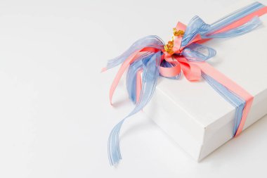 Beyaz arka planda mavi ve pembe kurdelelerle bağlanmış lüks kutu