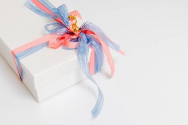 Beyaz arka planda mavi ve pembe kurdelelerle bağlanmış lüks kutu