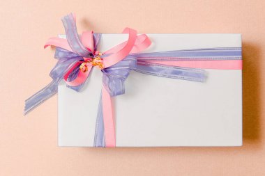 Lüks kutu pembe arka plan üzerinde mavi ve pembe kurdeleler ile bağlı