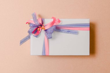 Lüks kutu pembe arka plan üzerinde mavi ve pembe kurdeleler ile bağlı