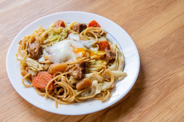 Ahşap arka planda domuz etli spagetti (Onsen tamago, Patates, enoki mantarı, soğan, brokoli, Japon tarzı)