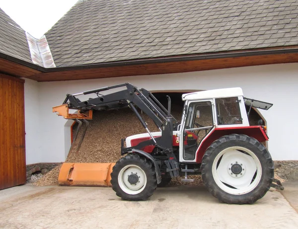 Güzel bir temiz traktör bir rur bir kiremit çatı kulübe yakınında duruyor
