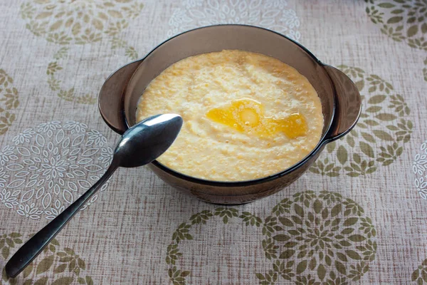 Tasty millet porridge with butter and milk in a glass plate — Stock Photo, Image