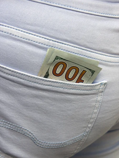 American hundred dollars stick out of the back pocket of blue je — Stock Photo, Image