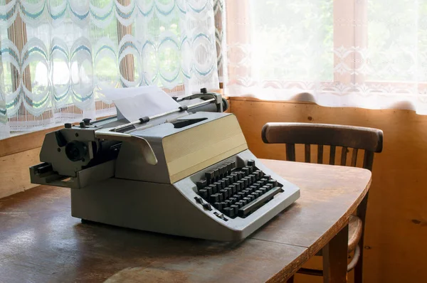 Uma Máquina Escrever Está Uma Mesa Velha Lado Uma Cadeira — Fotografia de Stock