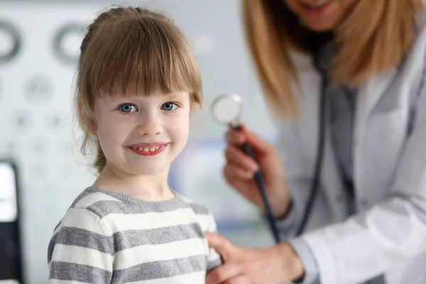 Sorrindo bonito pequeno paciente interagindo com médico feminino — Fotografia de Stock