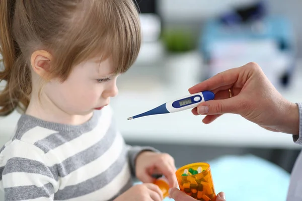 stock image Female hand holding thermometer measuring sick little girl